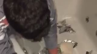 Guy reaching into bathtub full of tin foil