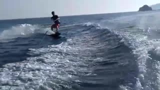 Guy in red shorts tries to flip while wakeboarding ends up falling