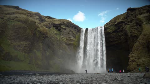 People at the Base of Large Waterfall