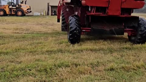 Moving a combine under a pole barn in the rain in the middle of being worked on farm Life