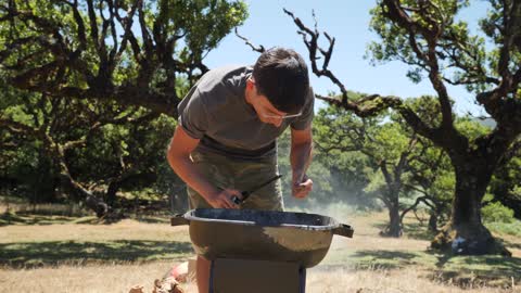 Young Man Light a Fire With a Gas Lighter