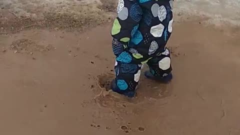 Happy childhood: boy and puddle