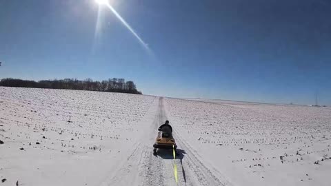 One snowmobiler helping out another snowmobiler
