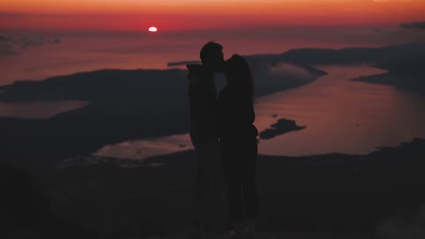 A Couple Kissing On The Mountain Top
