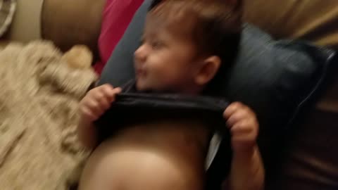 Adorable baby has fun finding his bellly button