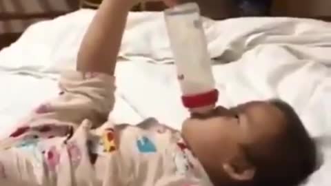 Smart baby uses his feet to hold the bottle