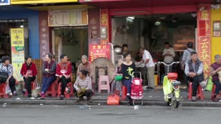 Chinese Family Waiting In Street For Next Bus