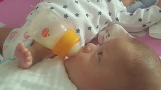Baby Helping Feed Brother With Rocking Leg