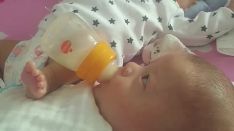 Baby Helping Feed Brother With Rocking Leg