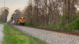 This is a New Engine pulling a freight train over a crossing