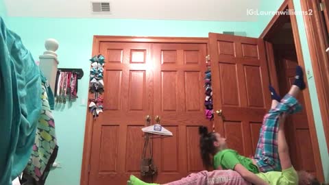 Green shirt girls try to do handstand on each other and fail