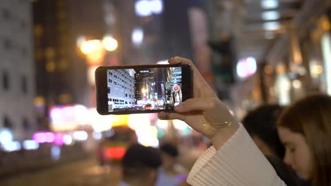 Person Filming Parade on Smartphone