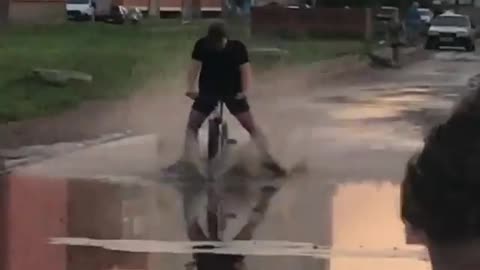 funny video cyclist runs into a puddle