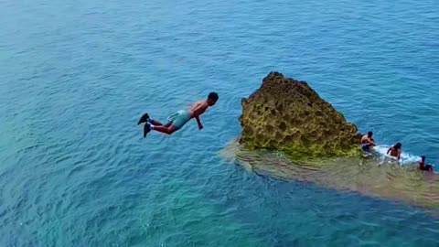 Beautiful swimmer jumping from the waterfall