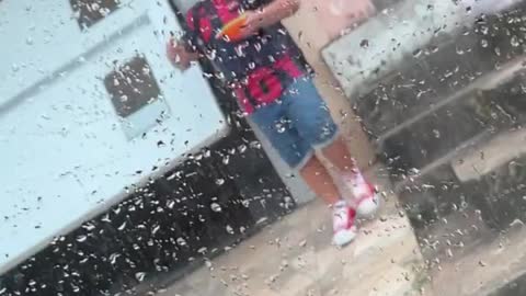 Little Brother Holding Tupperware Falls in Wet Driveway