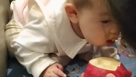 Baby eats food from mother's hand for the first time