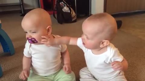 Cute twins fighting over pacifier!!