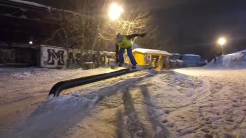 Snowboarder does trick on rail and falls on his face