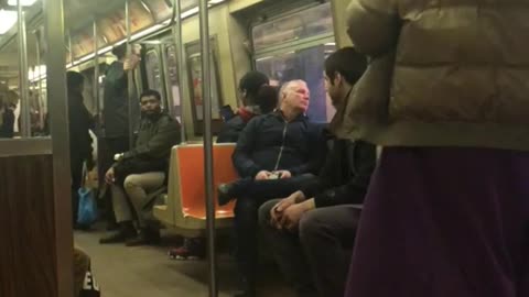 Woman yells at subway passenger and runs back and forth on train