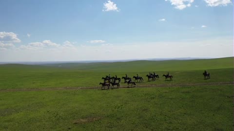 A group of people riding on grassland