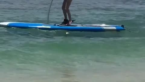 Surfboard peddle scooter beach guy