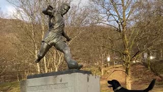 Dog Sees Statue of Man Kicking Soccer Ball, Waits to Chase After It