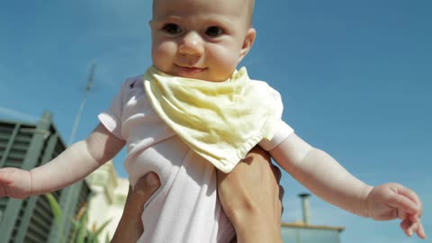 Baby being held in the air