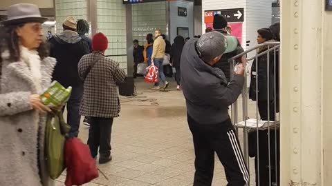 Man dances by himself to live band music in subway station
