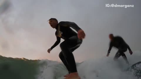 Guy pushes friend on surfboard friend falls off and into water