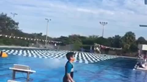 Man black and white shorts belly flop pool