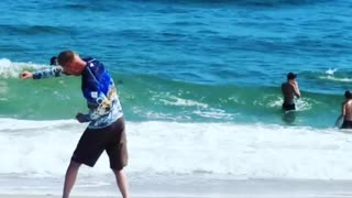 A man in a blue long sleeve shirt exercising on beach