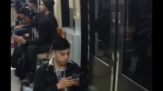 Man on phone texting does splits while on subway