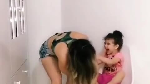 a mulher soltando pum quando dança com a filha