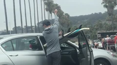 Guy in silver car surf board passenger seat