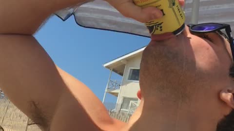 Shirtless guy drinks beer and spills it on himself