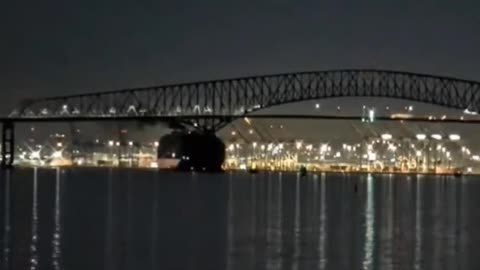 Large Ship hits large Baltimore Bridge Collision/Collapsing. Ship looks like it accelerates in to bridge notice smoke coming from top of ship suddenly blowing black smoke like in full acceleration. Lights turning on and off on boat