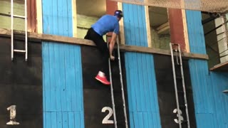 Competitive Firefighter Climbs Up Ladder