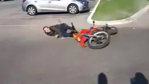 Man falls off a red dirt motorcycle