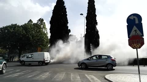 Massive smoke cloud behind car that seems almost ready to explode