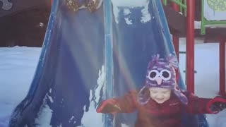 Snow two kids slide one faceplants