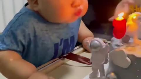 A cute boy blowing the candle while celebrating his birthday with his parents