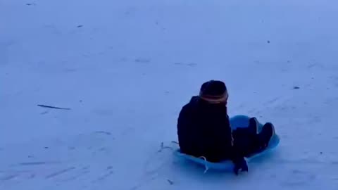 Kid enjoying sliding in snow