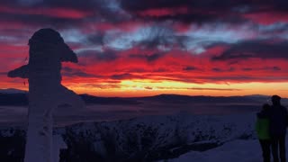 Couple enjoy truly spectacular sunset in the mountains