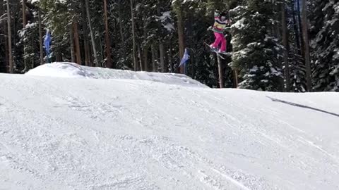 Girl skis of two ramps, falls face first hard into snow, both skis fall off
