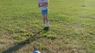 Girl gets hit in the stomach after sister kicks soccer ball and laughs