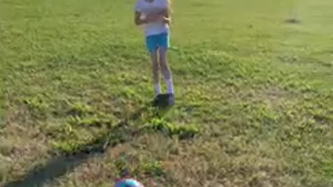 Girl gets hit in the stomach after sister kicks soccer ball and laughs