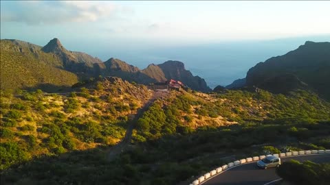 view from the height of the rocks winding road and ocean in the distance in the masca at sunset