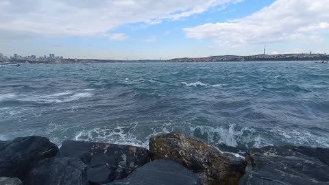Calm sea waves hitting the beach on the rocks