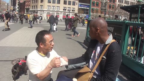 Luodong Massages Bald Black Man On Sidewalk