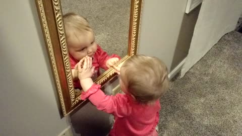 Curious baby fascinated by reflection